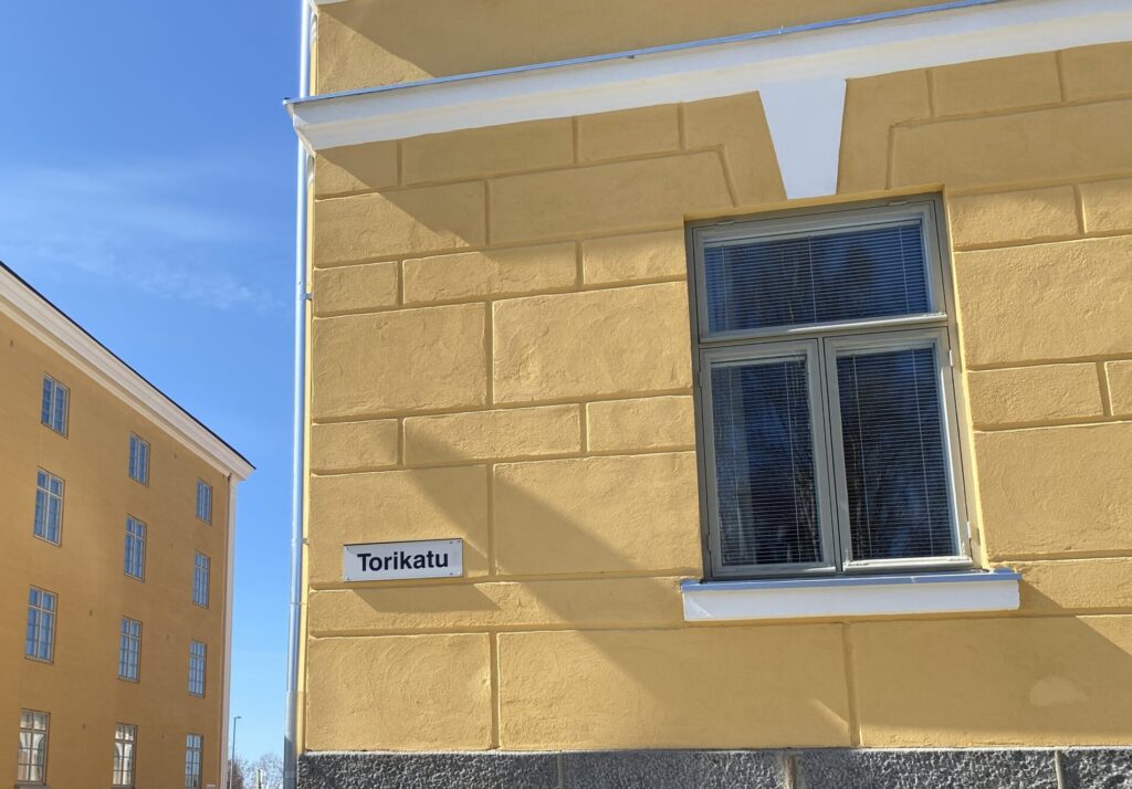 Maakuntien tilakeskuksen kuvituskuva kadunkulmasta, joka on katukyltin mukaan Torikadulla.